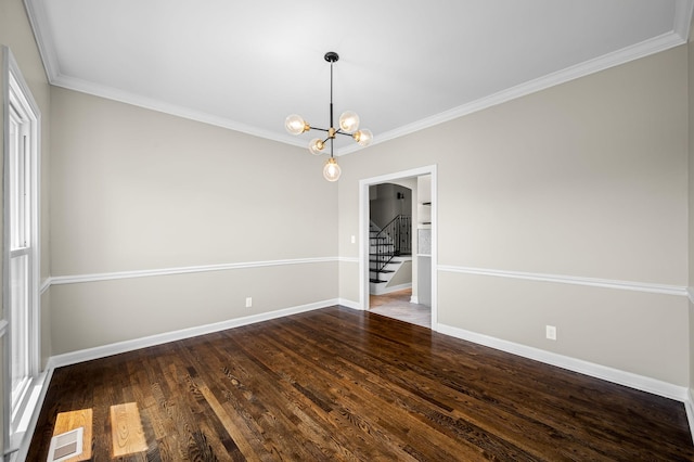 empty room with crown molding, dark wood-type flooring, and a chandelier