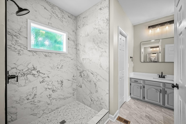 bathroom featuring a tile shower and vanity