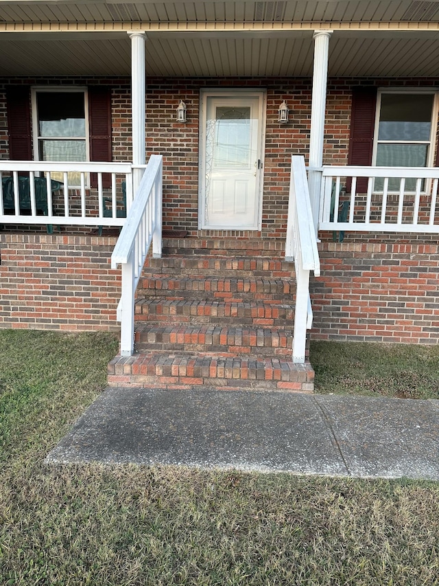 view of exterior entry featuring covered porch