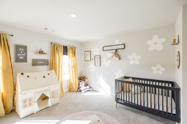 bedroom with light carpet and a nursery area