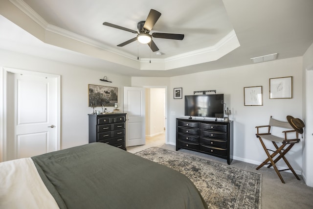 carpeted bedroom with ceiling fan, ornamental molding, and a tray ceiling