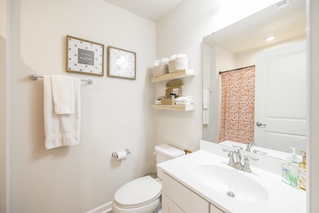 bathroom featuring walk in shower, vanity, and toilet