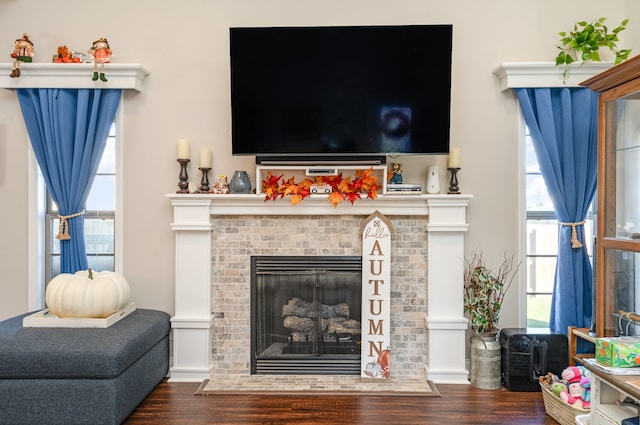 living room with dark hardwood / wood-style floors and a brick fireplace