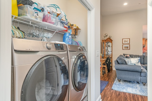 washroom with washing machine and dryer and dark hardwood / wood-style flooring