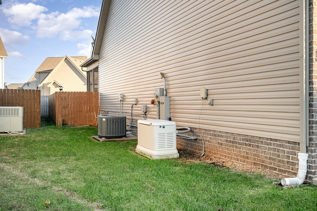 view of side of property featuring central AC unit and a lawn