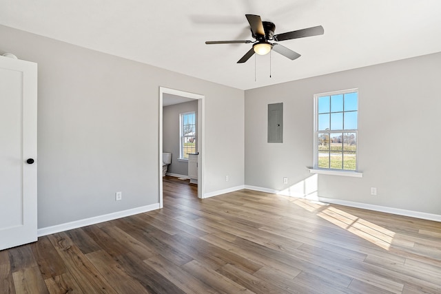 spare room featuring hardwood / wood-style floors, ceiling fan, and electric panel