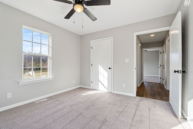 unfurnished bedroom with multiple windows, ceiling fan, and carpet floors