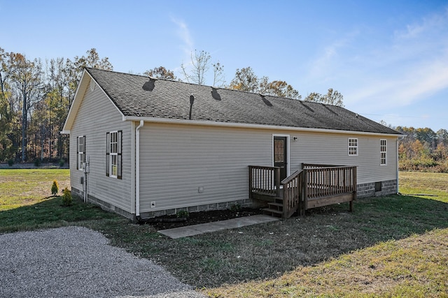 rear view of house featuring a deck and a yard