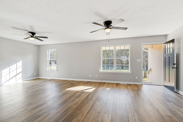 spare room featuring light wood-type flooring, plenty of natural light, and ceiling fan