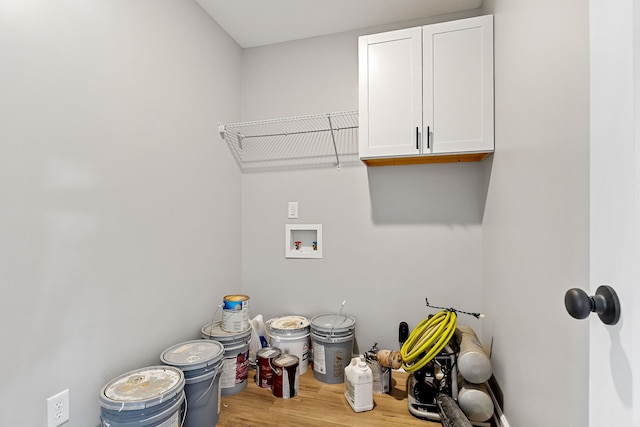 clothes washing area with cabinets, hookup for a washing machine, and hardwood / wood-style flooring