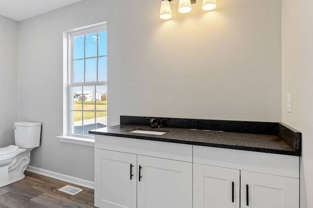 bathroom featuring hardwood / wood-style floors, vanity, toilet, and a healthy amount of sunlight