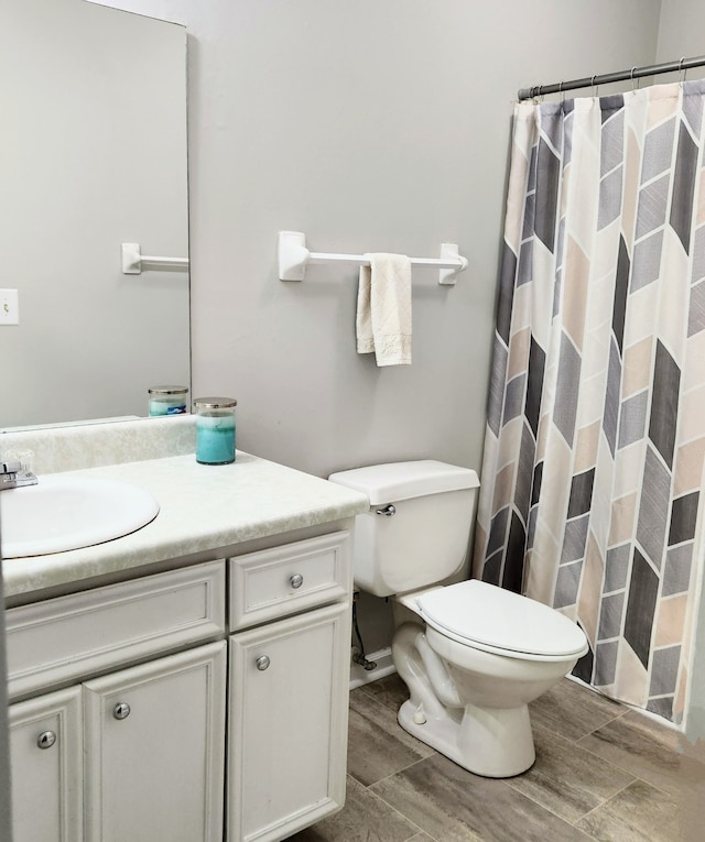 bathroom with a shower with curtain, vanity, and toilet