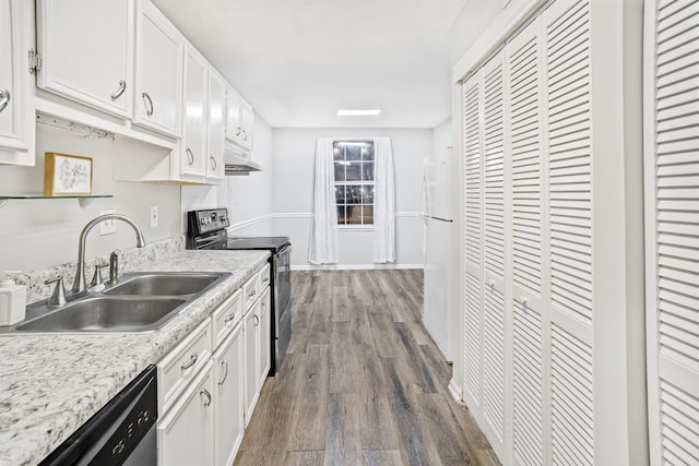 kitchen with black electric range oven, white cabinets, sink, stainless steel dishwasher, and hardwood / wood-style flooring