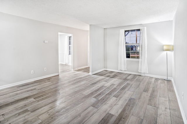 empty room featuring a textured ceiling and light hardwood / wood-style flooring