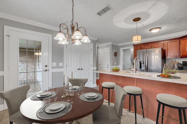 dining space with a textured ceiling, sink, crown molding, and an inviting chandelier