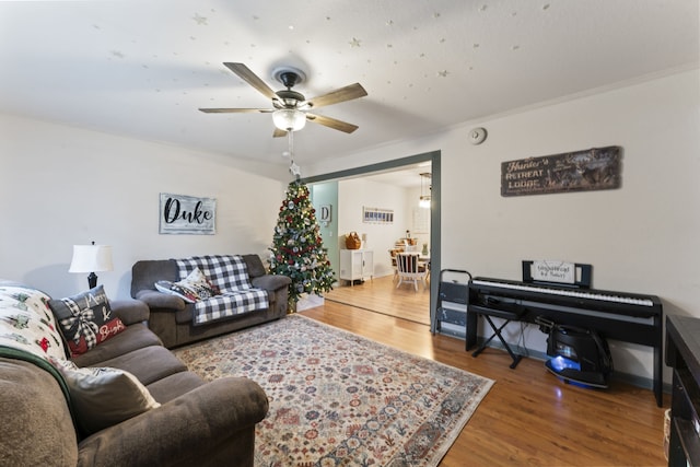 living room with ceiling fan, ornamental molding, and hardwood / wood-style flooring