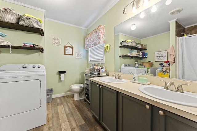 bathroom featuring separate washer and dryer, crown molding, toilet, vanity, and hardwood / wood-style flooring