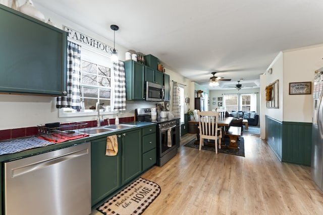 kitchen featuring appliances with stainless steel finishes, ceiling fan, sink, green cabinetry, and light hardwood / wood-style floors