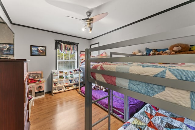 bedroom featuring ceiling fan, hardwood / wood-style floors, and ornamental molding