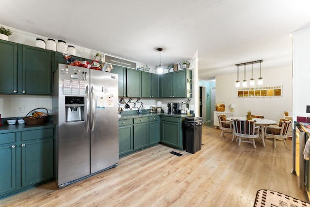 kitchen featuring green cabinetry, decorative light fixtures, stainless steel refrigerator with ice dispenser, and light wood-type flooring