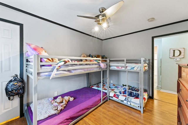 bedroom with light wood-type flooring, ceiling fan, and ornamental molding