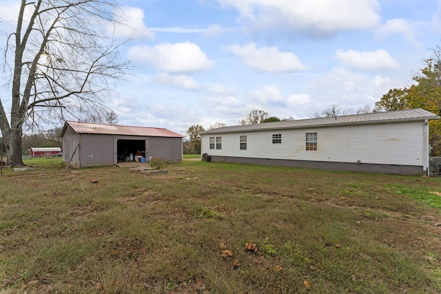 back of house with an outbuilding and a yard