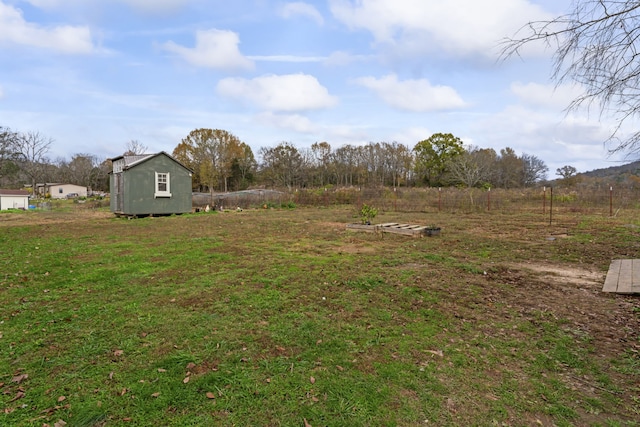 view of yard featuring a rural view and a storage unit