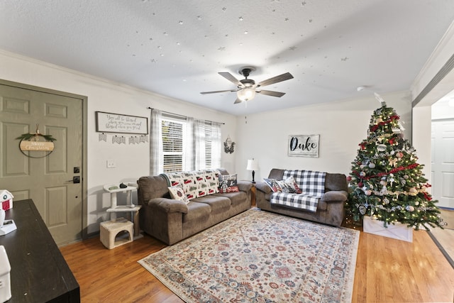 living room featuring crown molding, ceiling fan, and wood-type flooring