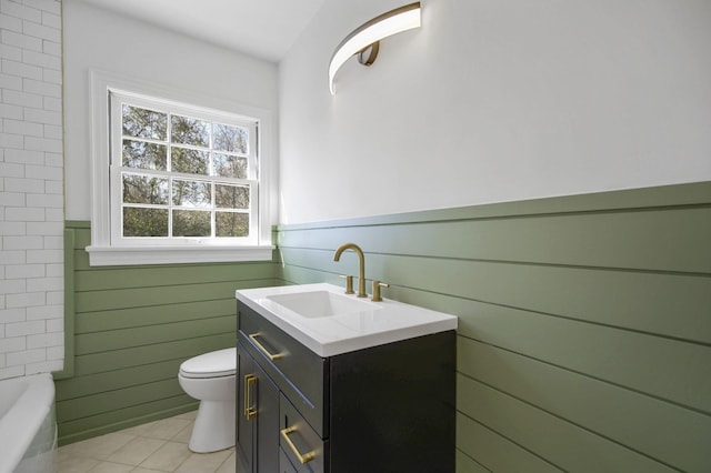 bathroom with a washtub, tile patterned floors, vanity, and toilet