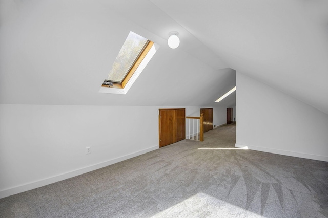 additional living space with carpet flooring and vaulted ceiling with skylight