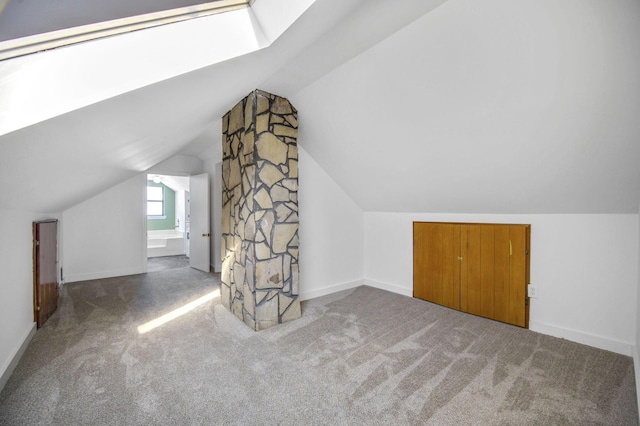 bonus room featuring vaulted ceiling with skylight and carpet