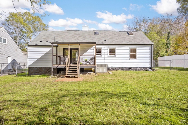 rear view of house featuring a yard, cooling unit, and a wooden deck