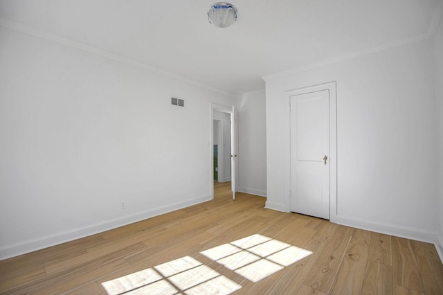 empty room featuring crown molding and light hardwood / wood-style floors