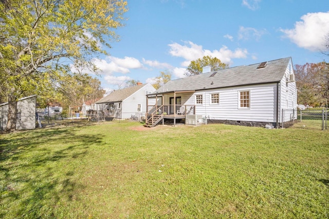 rear view of property featuring a lawn and a wooden deck