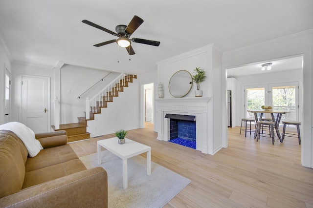 living room with ceiling fan, light wood-type flooring, and crown molding