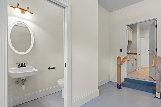 bathroom featuring concrete floors, toilet, and sink