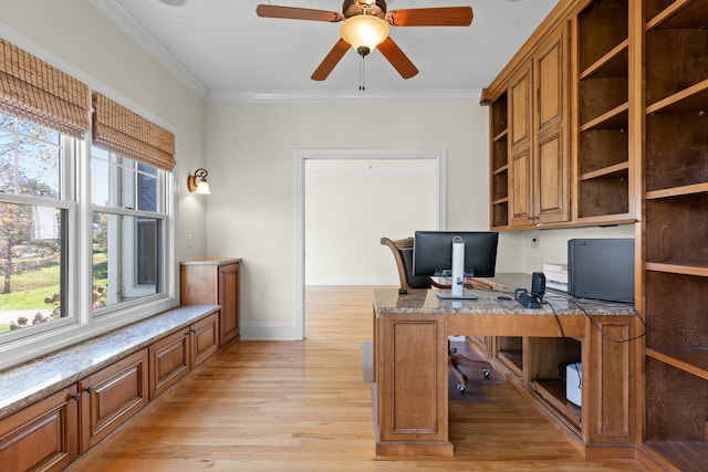 office area with ceiling fan, built in desk, crown molding, and light hardwood / wood-style flooring