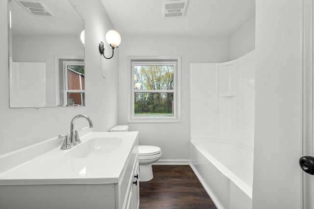 bathroom featuring visible vents, toilet, wood finished floors, and vanity