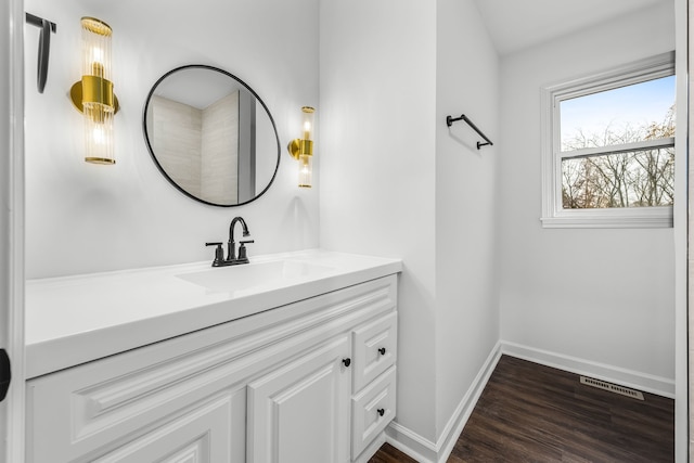 bathroom featuring vanity, wood finished floors, baseboards, and visible vents