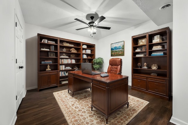 office area featuring visible vents, baseboards, dark wood finished floors, and a ceiling fan