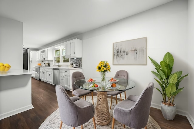 dining space featuring dark wood-style floors and baseboards