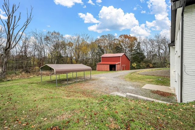 view of yard with a carport and an outbuilding