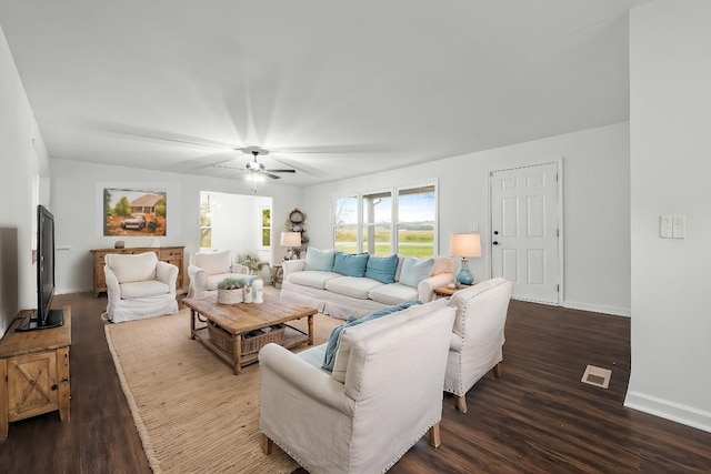 living area featuring visible vents, a ceiling fan, dark wood-type flooring, and baseboards