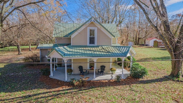 back of house featuring a patio, a storage unit, and a lawn