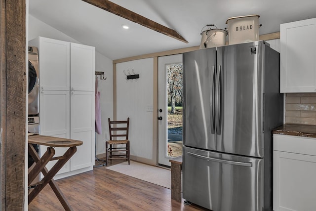 kitchen with white cabinetry, vaulted ceiling with beams, stainless steel fridge, and dark hardwood / wood-style flooring