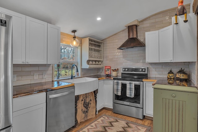 kitchen with stainless steel appliances, white cabinetry, wall chimney exhaust hood, and sink