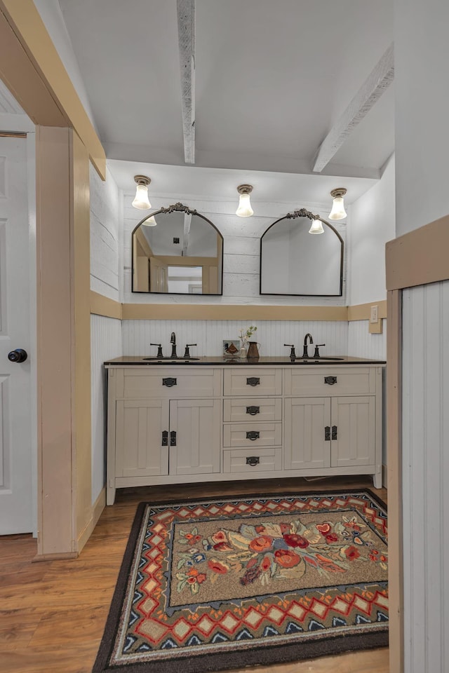 bathroom with beam ceiling, hardwood / wood-style floors, and vanity