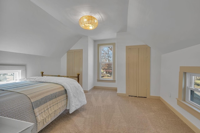 bedroom with lofted ceiling and light carpet