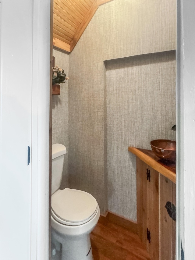 bathroom featuring wood-type flooring, lofted ceiling, toilet, and wooden ceiling