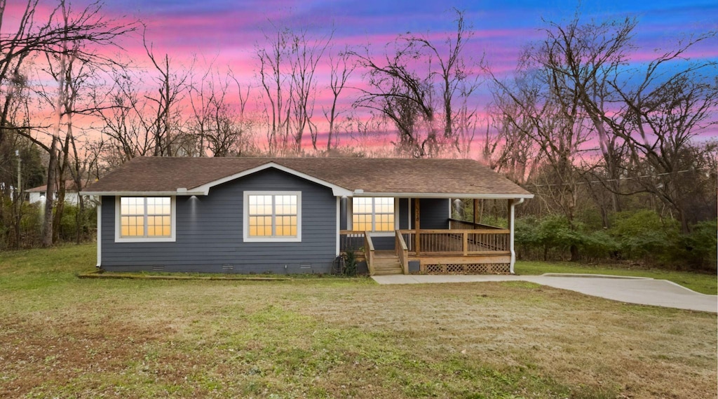 view of front of house featuring covered porch and a lawn